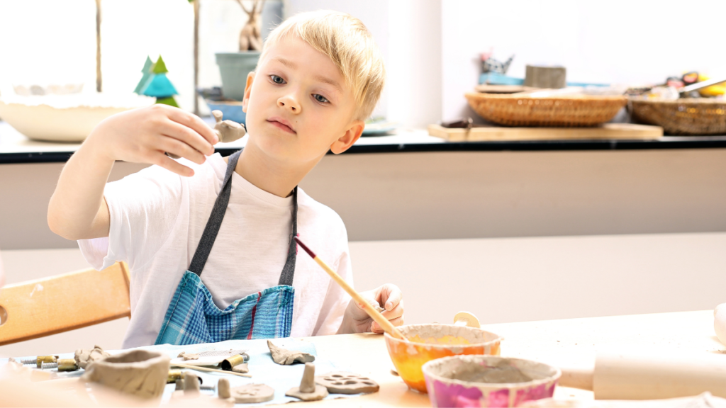 Kid is making a ceramic cup - Canva Stock